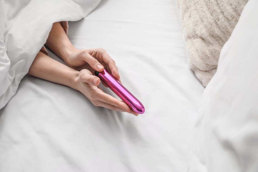 Woman with vibrator in her bed