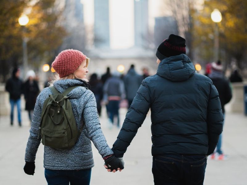 couple holding hands and wearing winter jackets