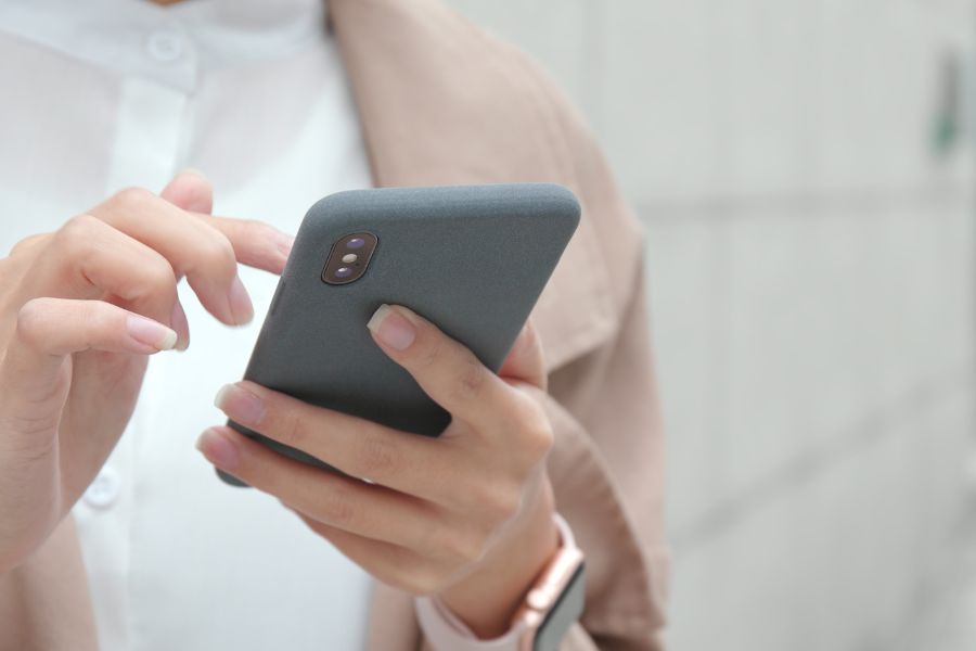 Hands of women using a cell phone