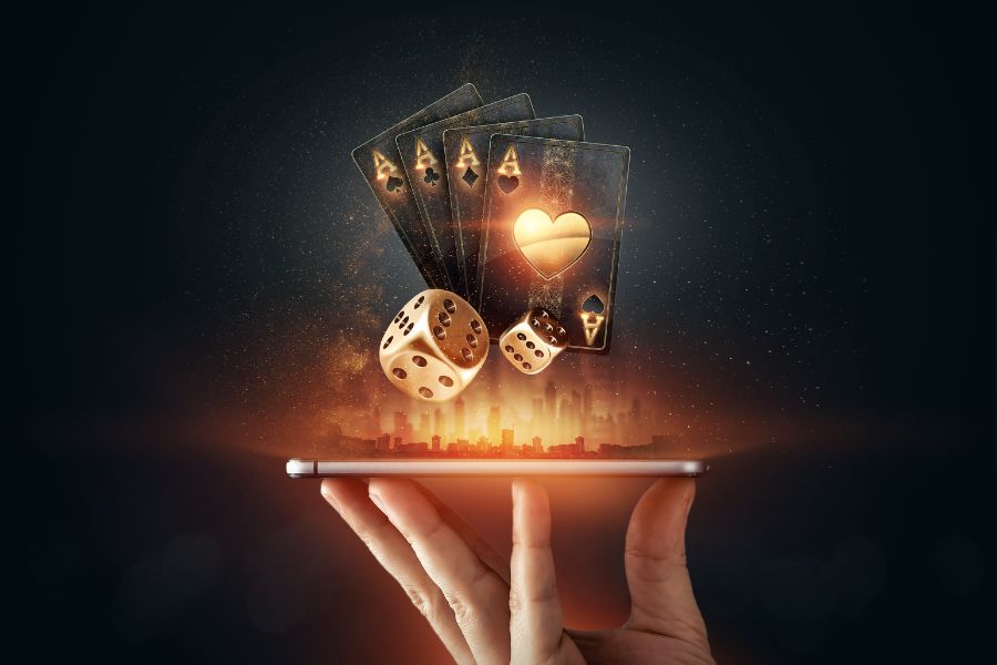 Man holding a phone with playing cards roulette and chips