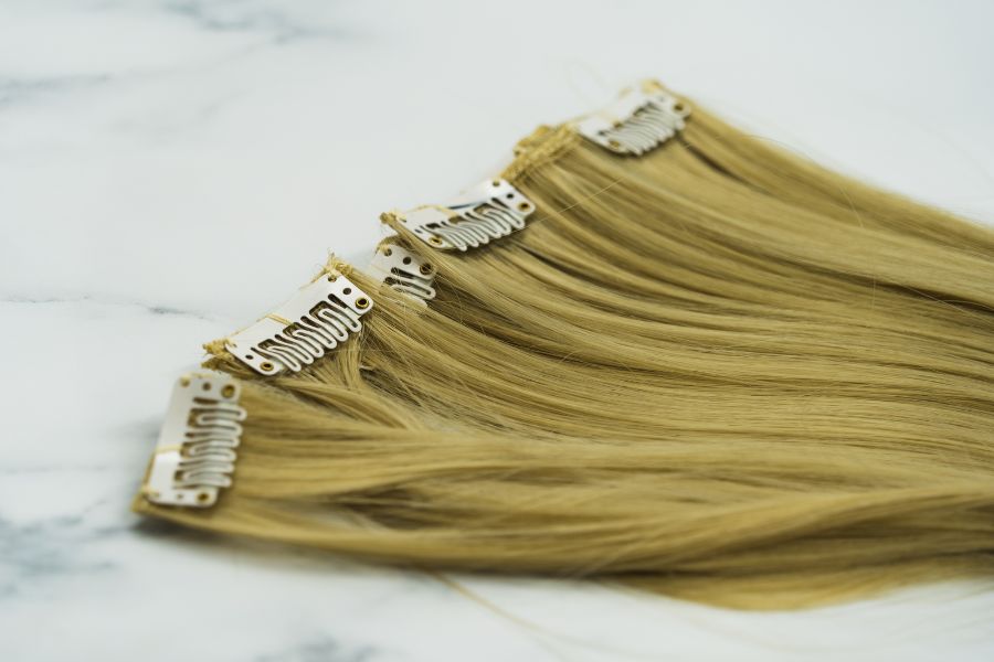 Clip-in hair extensions on light surface