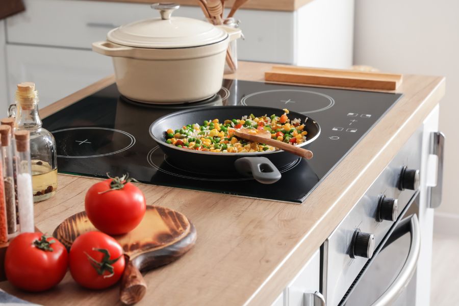 Modern electric range and utensils in kitchen